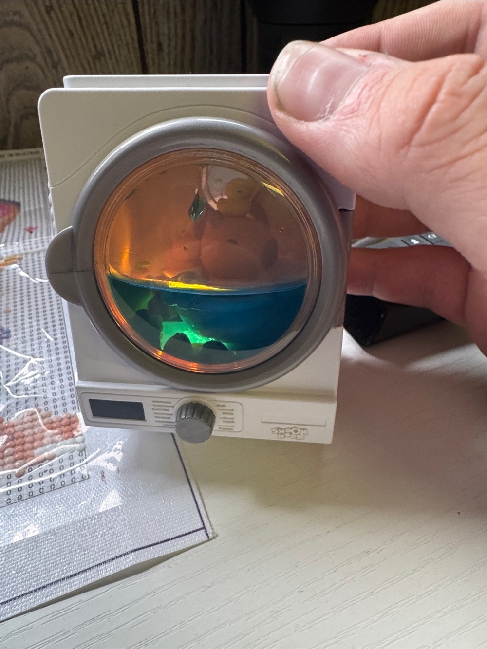 Compact White Digital Camera Accessory with Orange and Blue Liquid Display